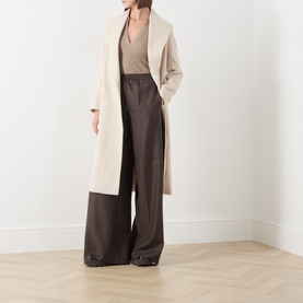 Model wearing Max Mara Main mud wide-leg wool trousers, styled with a cream longline coat and taupe top.