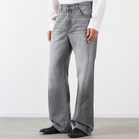 Model wearing Acne ash grey wide-leg jeans in cotton-lyocell blend, styled with a white shirt and black leather shoes.