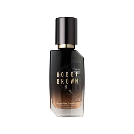 Bobbi Brown Serum Skin Foundation in a dark glass bottle with gold cap, medium-dark shade visible through packaging.