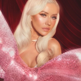 Model with Charlotte Tilbury Beauty Advent Calendar, wearing glam makeup with platinum blonde hair