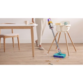 Dyson V15 Submarine cordless vacuum in multi-colour, in use on hardwood floor near dining table and high chair
