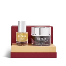 Elemis Ultra Smart Midnight Renewal Gift Set featuring a gold facial oil and dark cream jar on a red display stand.
