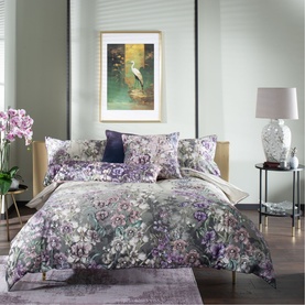 House of Norris Duvet Set in multi floral purple, lilac and grey print, styled on a double bed with matching pillowcases