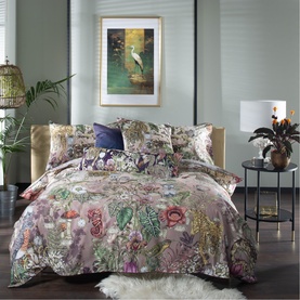 House of Norris Multi Duvet Set with bold botanical floral print in pink, green and purple tones, styled on a double bed