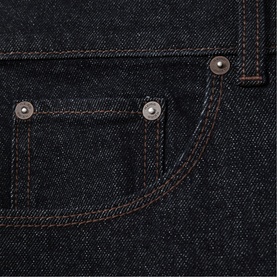 Reiss raw indigo denim jeans close-up showing coin pocket, copper rivets, and contrast stitching detail