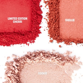 Benefit blush powder swatches in three shades: Limited Edition Cherri (red), Shellie (coral-pink), and Cookie (nude pink)