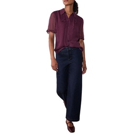 Model wearing Whistles red spot print short sleeve blouse with navy wide-leg jeans and brown loafers