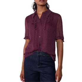 Model wearing Whistles red polka dot short-sleeve blouse with ruffle neck detail, styled with dark blue jeans