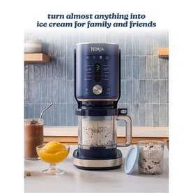 Ninja Ice Cream Maker 11-in-1 in navy blue, shown on kitchen counter with ice cream desserts and blue lid alongside