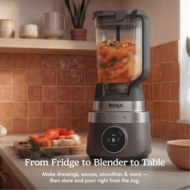 Ninja CrushBOSS Intelligent Blender 1200W in black, blending sauce, on a kitchen counter with terracotta tiles
