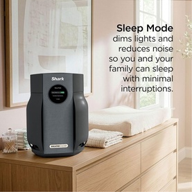 Shark air purifier in dark grey on wooden dresser in bedroom setting, highlighting Sleep Mode feature for quiet operation.