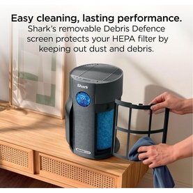 Shark Breathe Clear Compact Charcoal air purifier in dark grey, with removable Debris Defence screen being detached by hand.