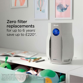 Shark Breathe Clear Compact Dove air purifier in grey, shown in a child's room with colourful wall art and toys on a white desk.