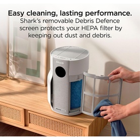 Shark Breathe Clear Compact Dove air purifier in white, with removable Debris Defence screen shown being cleaned with blue cloth.