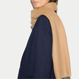 Model with Jigsaw camel scarf draped loosely around neck, styled with a navy blazer.