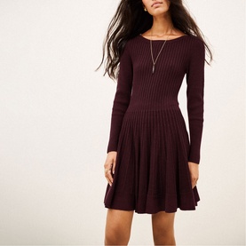 Model wearing Bash purple ribbed knit long-sleeve fit-and-flare dress with delicate gold necklace