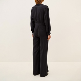 Model wearing Bash Womens French Dress in grey, shown from behind, featuring long sleeves, belted waist, and wide-leg trousers