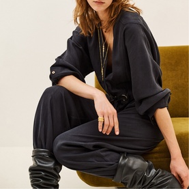 Model wearing Bash Womens French Dress in grey, styled with black leather knee-high boots and gold jewellery