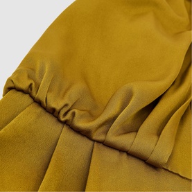 Reiss chartreuse green dress close-up showing elasticated waist detail and pleated skirt in fluid fabric
