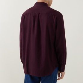 Model wearing Lacoste Casual Shirt in Oxalis burgundy cotton, rear view, with blue jeans visible at hem.