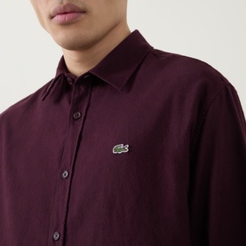 Model wearing Lacoste Casual Shirt in Oxalis burgundy, 100% cotton with embroidered crocodile logo, close-up detail shot