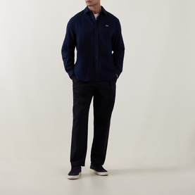 Model wearing Lacoste Navy Blue cotton casual shirt with black trousers and cream trainers, full-length view.