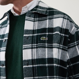 Model wearing Lacoste Casual Shirt in green and white check flannel with crocodile logo badge, styled over a green knit sweater.