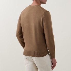 Model wearing Lacoste cookie wool crew neck jumper, rear view, styled with cream trousers