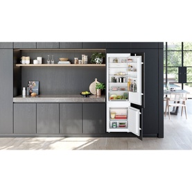Siemens SDA Built-In Fridge-Freezer in white, shown open and integrated into a modern grey kitchen with shelving