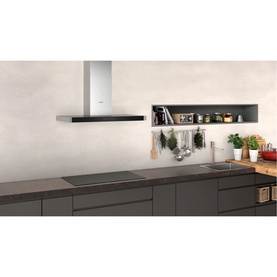 Neff 90cm Chimney Cooker Hood in silver with black trim, mounted above dark hob in modern kitchen setting