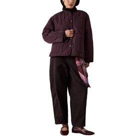 Model wearing Whistles red quilted jacket with dark wide-leg trousers, styled with a plaid scarf and flat shoes.