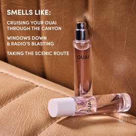 Ouai EDP fragrance in travel-size and full-size clear bottles with white caps, displayed against textured tan leather background.