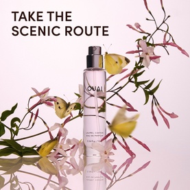 Ouai Jardin Eau de Parfum glass bottle on pink surface with delicate pink flowers and yellow butterflies