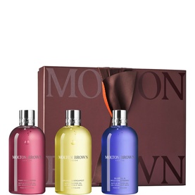 Molton Brown bath and body gift set with three large bottles in pink, yellow, and blue, presented with signature branded gift box.