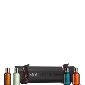 Molton Brown Bath & Body gift cracker set with five miniature bottles, presented in a black branded cracker packaging with red ribbon ties.