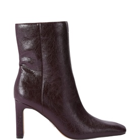 Dark burgundy crinkled patent leather ankle boot with square toe, side zip, and stiletto heel on cream background