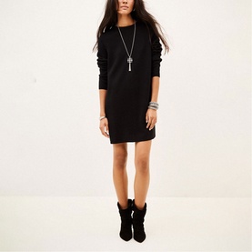 Model wearing Bash black long-sleeve mini sweatshirt dress, styled with a cross pendant necklace and black ankle boots