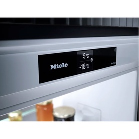 Miele Built-in 70/30 Fridge-Freezer digital control panel displaying 5&deg;C fridge and -18&deg;C freezer temperatures, with chilled items visible below.