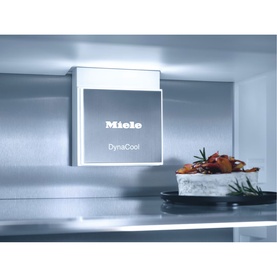 Miele Built-in 70/30 Fridge-Freezer interior showing DynaCool unit with chilled shelving and fresh food visible inside.