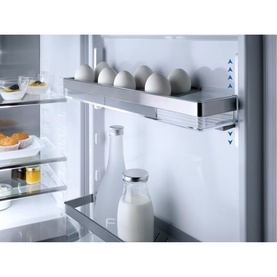 Miele Built-in 70/30 Fridge-Freezer interior detail showing adjustable stainless steel door shelf with eggs, milk bottle and condiments visible