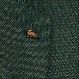 Magee 1866 green tweed fabric close-up with small gold lion logo pin badge detail