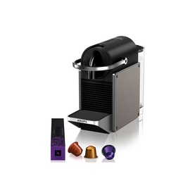Krups Nespresso Pixie Titanium coffee machine in black, shown with four assorted Nespresso capsules in red, orange, brown and purple