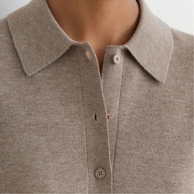 Model wearing Reiss beige fine knit polo top, close-up showing collared neckline with button placket detail