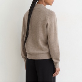 Model wearing Reiss beige knit jumper with collar detail, styled with black trousers, rear view.