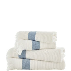 The Lyndon Company blue stripe towel set, cream waffle-textured cotton with blue band detail and fringe trim, stacked set of four