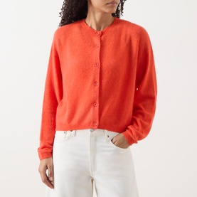 Model wearing American Vintage coral cotton-blend cardigan with button front, styled with white wide-leg trousers.