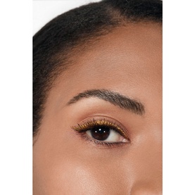 Model with Chanel eye liner/pencil in gold applied to lower lash line, shown in close-up eye detail shot