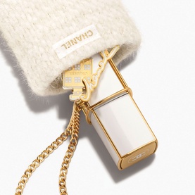 Chanel Fragrance Set with white enamel miniature bottle and gold-tone chain, nestled in a cream textured pouch with CC charm detail.