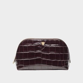 Deep burgundy croc-embossed cosmetics pouch with gold-tone zip and logo charm, dome-shaped silhouette