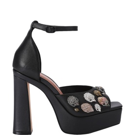 Kurt Geiger London black leather platform sandals with ankle strap, block heel, and mixed-tone embellished skull detail on vamp.
